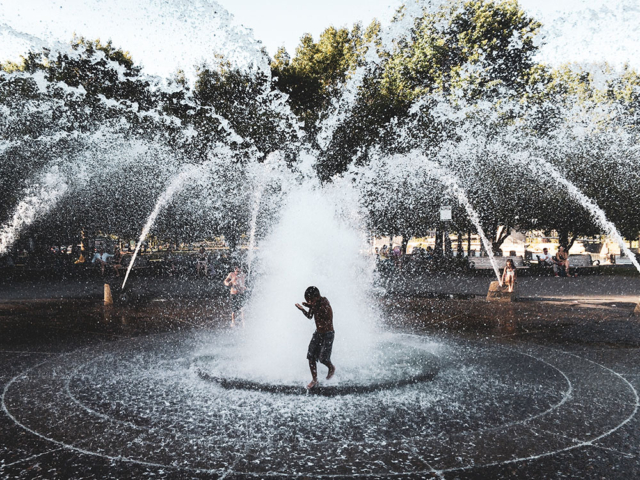 photograph of a boy playing at fountain park